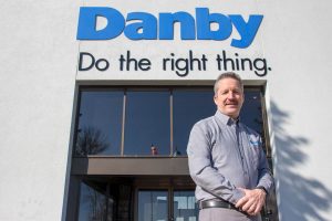Jim Estill in front of Danby Appliances Sign 